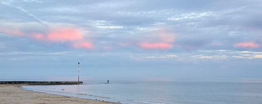 Panoramic October sky over the sea with a fisherman in the water