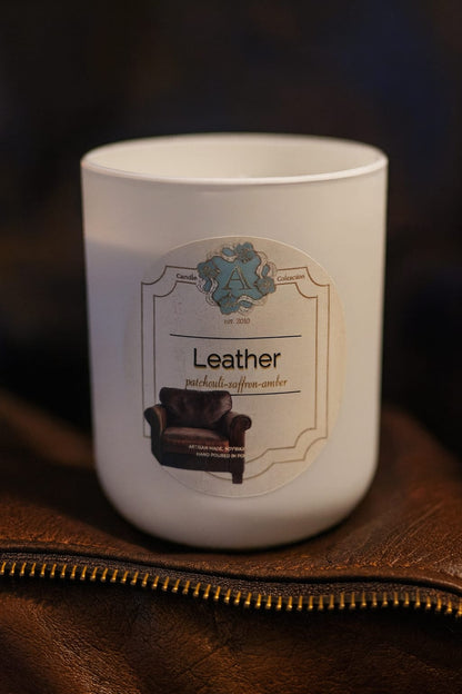 leather soy wax scented candle in a white jar on a brown leather surface – A Candle Collection